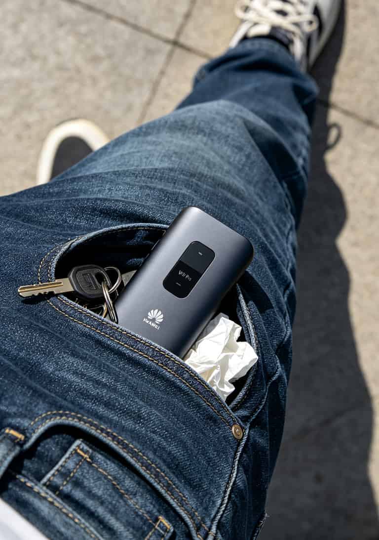 亏了三千块才搞明白:华为随身WiFi配一张“不限地区的流量卡”,一年能省下一半网费 华为随身WiFi Pro放在牛仔裤口袋里的照片,展示厚度和便携性