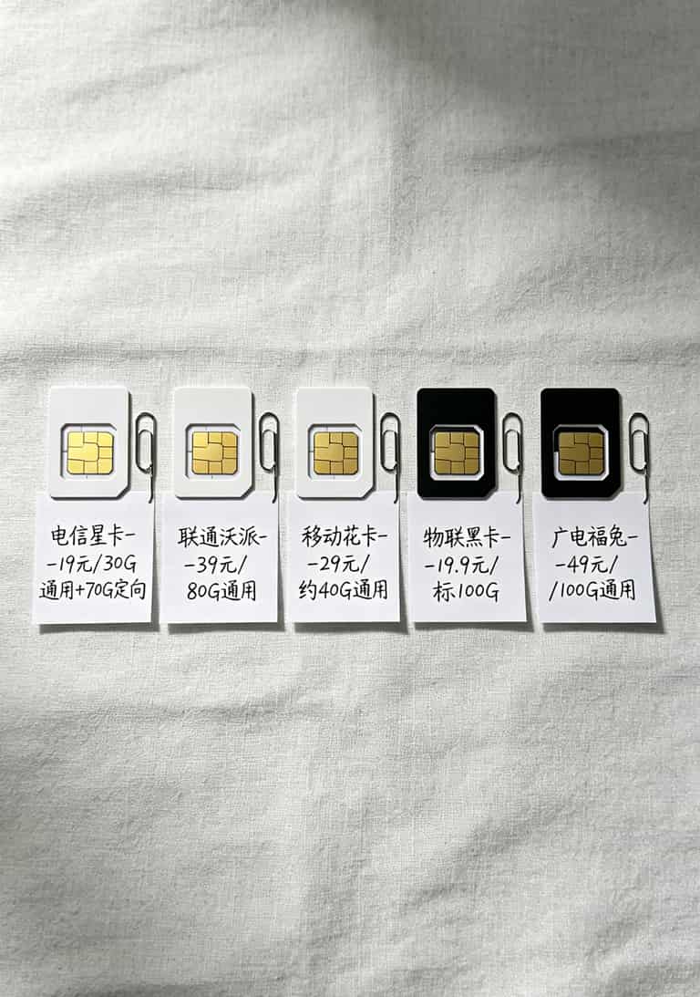 我买了十几张流量卡,100g流量卡一个月多少钱终于搞明白了(附避坑指南) 五张不同运营商的流量卡并排摆放,每张下方手写标注月租价格和通用流量